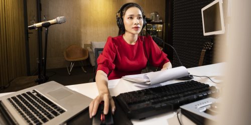 Interpret in cabina cu casti si microfon